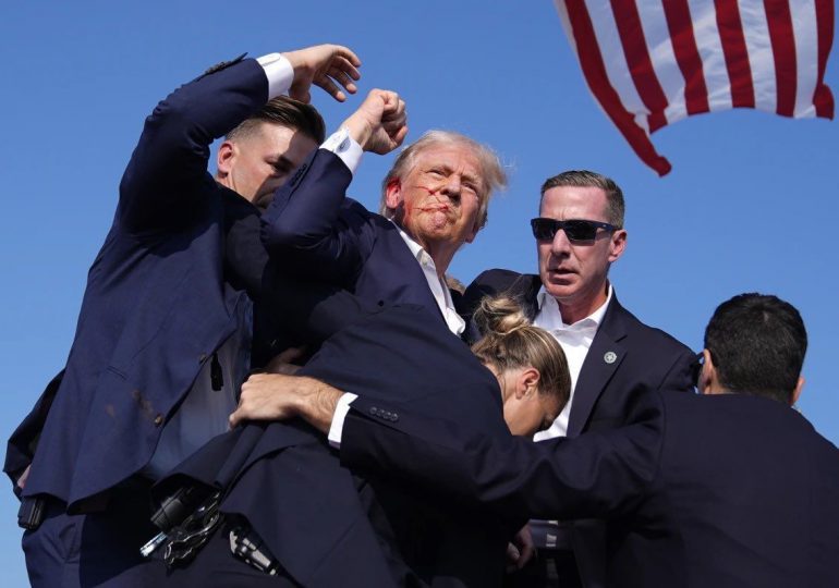 Trump levanta el puño mientras es evacuado del escenario de su mitin