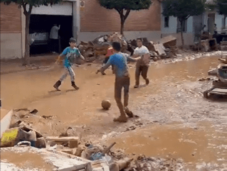 Niños juegan en el barro en medio del caos por la DANA en Valencia